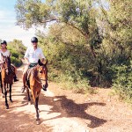 a young couple riding horses on a trail