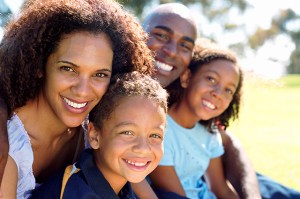 A smiling family of four: a mother, father and two kids.