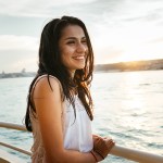 woman smiling aboard river cruise ship as the sun sets