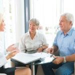 older couple discussing term vs. whole life insurance with an agent