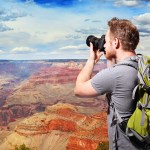 travel photography tips - man taking a photo overlooking mountains