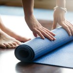 person unrolling a yoga mat