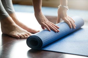 person unrolling a yoga mat