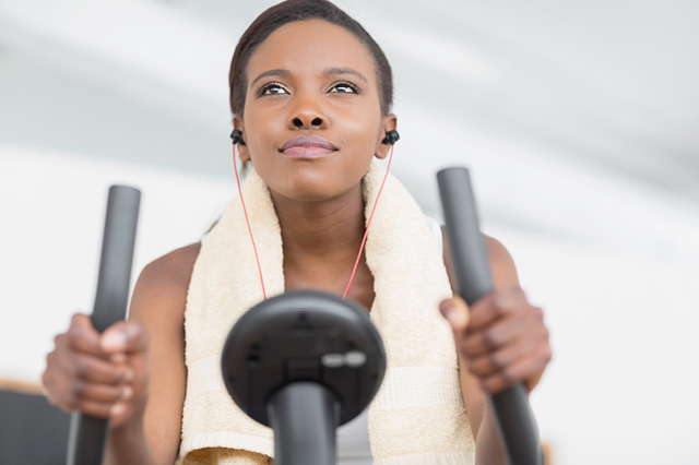woman working out on a treadmill listening to music