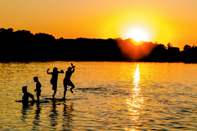 cheap beach vacations - family playing in the water
