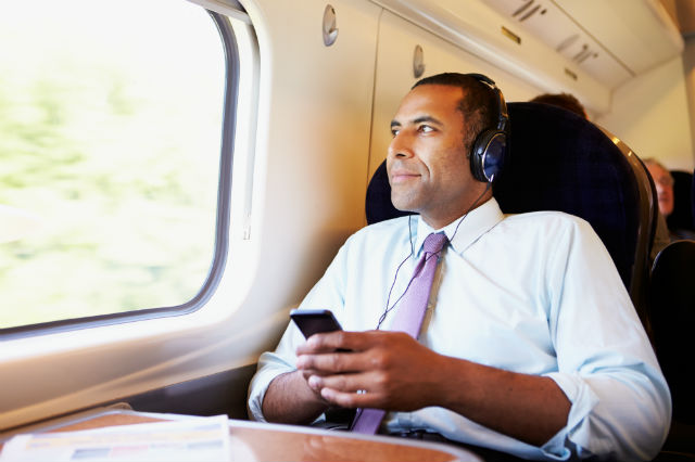 man sitting down listening to a podcast through her device