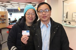 Paul Lee and Mimi Man at the Garden City, N.Y., branch, holding a membership card.