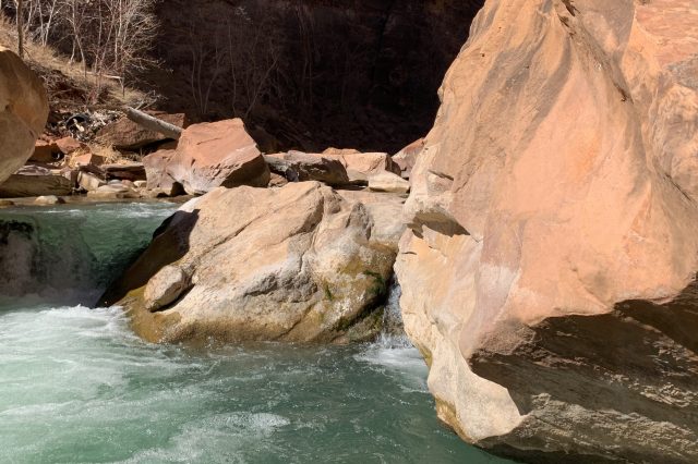 Green water flows over orange rock