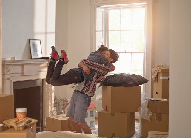 happy new homeowners celebrating while unpacking. Marry the house, date the rate. 