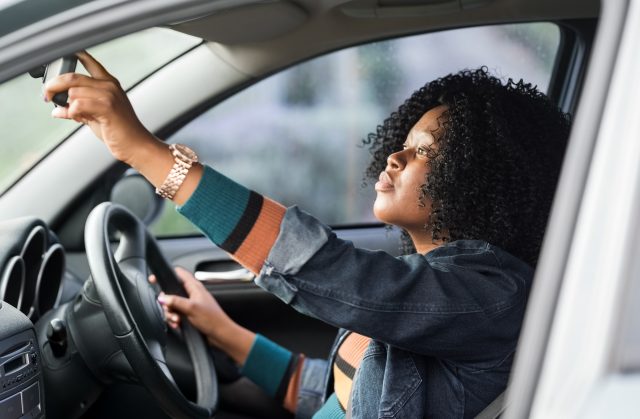 teen driver checks rearview