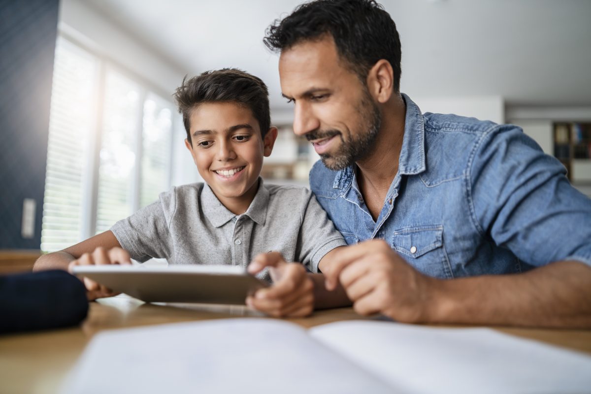 Father and son using tablet and doing homework